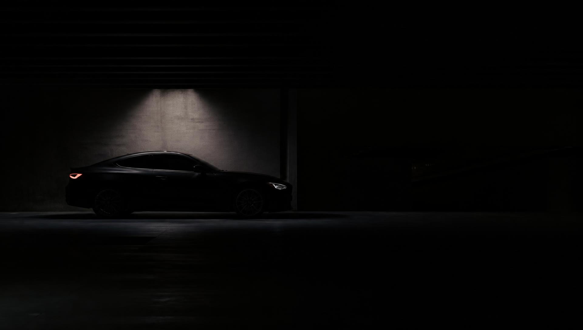 Cupê premium escuro em estacionamento noturno